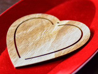 Wooden heart on a red shinny tray