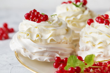 Pavlova cakes with cream and fresh summer berries. Close up of Pavlova dessert with forest fruit and mint. Food photo