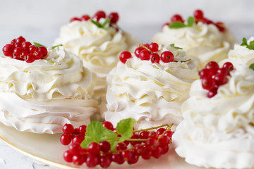 Pavlova cakes with cream and fresh summer berries. Close up of Pavlova dessert with forest fruit and mint. Food photo