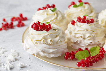 Pavlova cakes with cream and fresh summer berries. Close up of Pavlova dessert with forest fruit and mint. Food photo