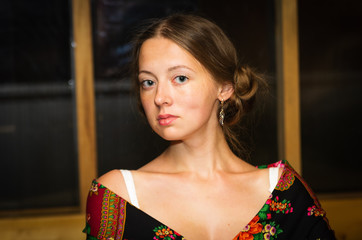 Portrait of a brown-haired girl in a flowered shawl draped over her shoulders. A close-up portrait...