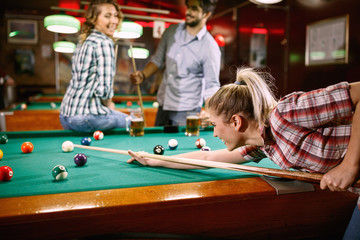 Obraz na płótnie Canvas woman aiming on pool ball while playing billiard..