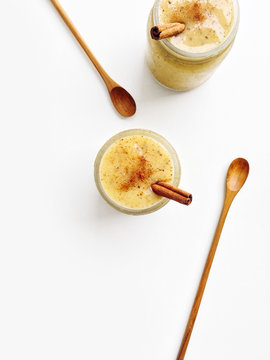 Mango yogurt smoothie with chia seeds and cinnamon on a white background, top view copy space