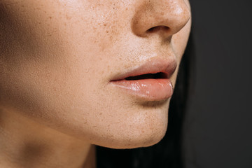 cropped view of girl with freckles on face isolated on grey