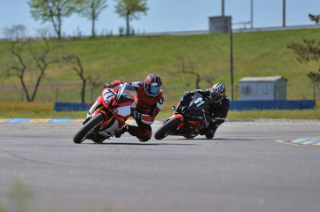 Road racing motorcykel in high speed into a curve, panning shot