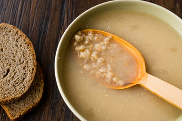 Wheat Soup with Chicken Broth Bouillon on Dark Wooden Surface.