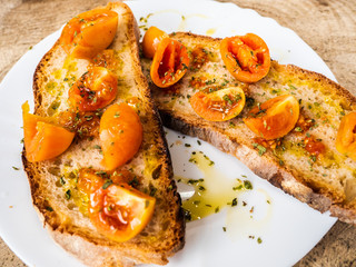 grilled bread bruschetta with Italian tomatoes, orange color, very good and lasting, seasoned with olive oil and oregano, for a healthy breakfast