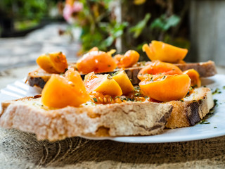 grilled bread with Italian tomatoes, orange color, very good and lasting, seasoned with olive oil and oregano, for a healthy breakfast in the country garden