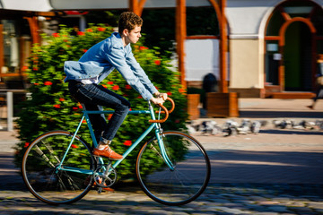 Young man biking in city park