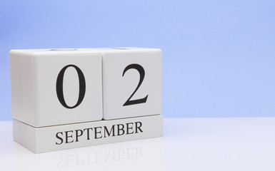 September 02st. Day 2 of month, daily calendar on white table with reflection, with light blue background. Autumn time, empty space for text