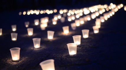 A group of candles burning in street on the asphalt. Day of Remembrance for the Bereaved