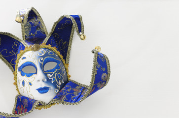 blue with gold elegant traditional venetian mask over white wooden background