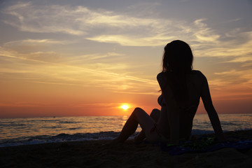 Beautiful woman on the beach at sunset. Woman enjoy on the beach in Greece