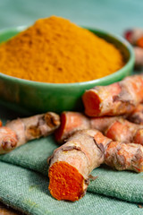 Fresh turmeric or curcuma root and dried powder, wildly used in Asia and India as spice, food ingredient and for medicinal purposes.