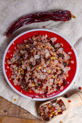 Gross sea salt mixed with dried red hot chili pepper, colorful seasoning close-up