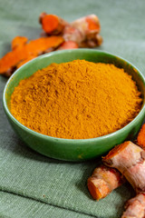 Fresh turmeric or curcuma root and dried powder, wildly used in Asia and India as spice, food ingredient and for medicinal purposes.