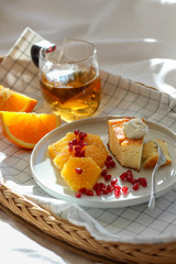 Morning scene with a piece of cake and some slices of orange with tea on a tray