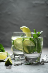 Mojito cocktail with ice, mint and lime on a dark background top view.