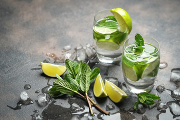 Mojito cocktail with ice, mint and lime on a dark background top view.