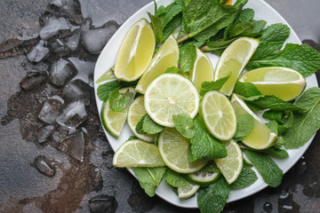 Ingredients for mojito cocktail mint, lime and ice on a dark background top view 