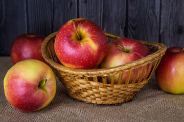 Red-yellow ripe apples in and around the basket