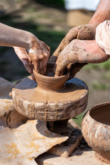 people make a ceramic pot on the potter's wheel