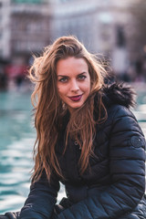 fashionable portrait of young beautiful woman in a European city on a sunny winter day