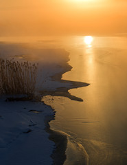 wonderful winter scene. Frosty, misty morning on the small river. frost covered trees in the warm...