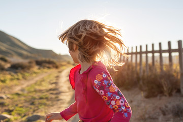  Little girl running through the Spanish landscape, Rambla del Playazo, Cabo de Gata - Nijar Natural Park, Spain