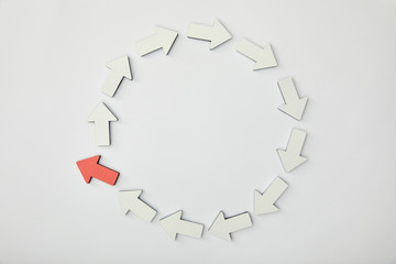 top view of circle with white pointers and red arrow on grey background
