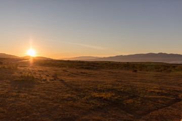 Obraz premium Sun hiding between mountains, sunset in Cabo de Gata-Nijar Natural Park, Andalusia, Spain