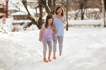 Cheerful children play barefoot in snow. hardening