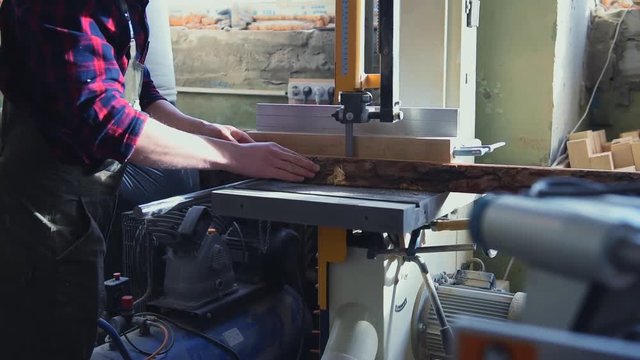 Construction worker cutting wooden board with circular saw