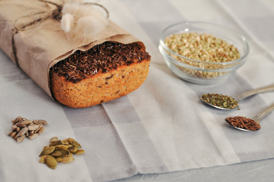 Raw homemade vegan sourdough bread made of green buckwheat with flax seeds, sunflower, pumpkin in a paper Kraft bag. Healthy and proper nutrition.