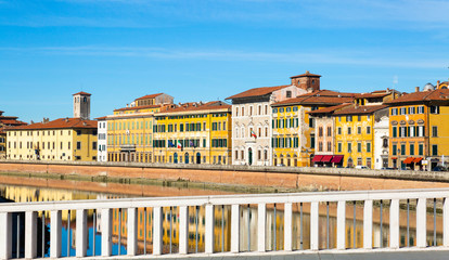 Old buildings in Pisa reflected in the Arno River