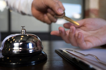 Close up of hand guest takes room key at check-in desk of the hotel.Hotel concept.