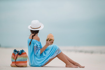 Young woman drinking coconut milk during tropical vacation