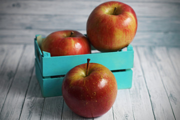Red apples on white wooden background