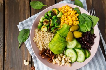 budha bowl with brussel cabbage, corn, quinoa, cucumbers,nuts, avocado and spinach