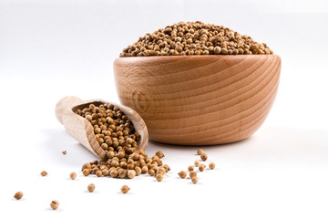 coriander seeds  in wooden bowl and scoop isolated on white background.