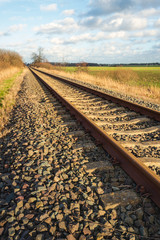 Rusty single-track train tracks in a rural area