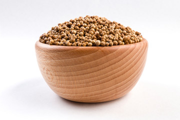 coriander seeds  in wooden bowl isolated on white background.
