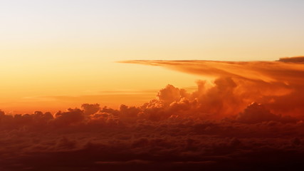  footage of beautiful sunset clouds from airplane window. Bright intense orange cloudscape view from above. Flight through moving yellow clouds in the evening sunshine.