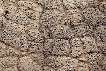 Broken and fragmented pavement of a road.