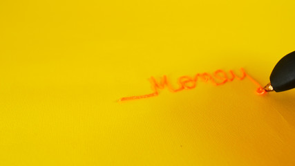 A man's hand writes the money written on yellow background with 3d printer pen, footage ideal for topics such as innovation and technology