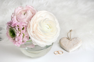 Wedding composition. A gentle picture for a story or a blog. Pink roses, heart, rings and a fluffy rug.  Flat lay. Copy space.