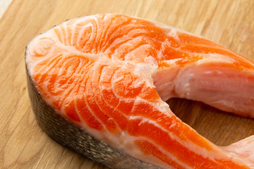 Bright red raw salmon lying on the wooden surface
