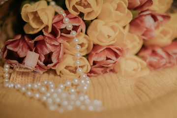 Pink and yellow tulips bouquet lying on a yellow knitted fabric