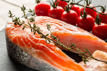 Raw red fish slice with thyme and cherry tomatoes