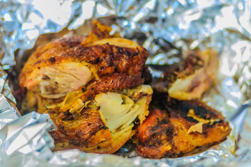 Chicken grilled wrap with aluminium foil. Grilled chicken on aluminum foil background.